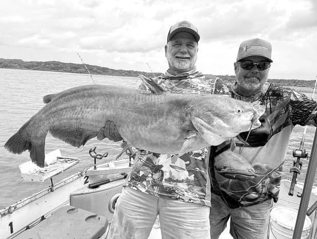 Jeff Rice (leftt) and Lake Tawakoni catfish guide Tony Pennebaker show off a giant blue catfish landed from shallow water last week.