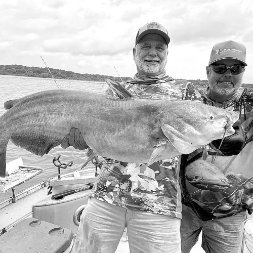 Jeff Rice (leftt) and Lake Tawakoni catfish guide Tony Pennebaker show off a giant blue catfish landed from shallow water last week.